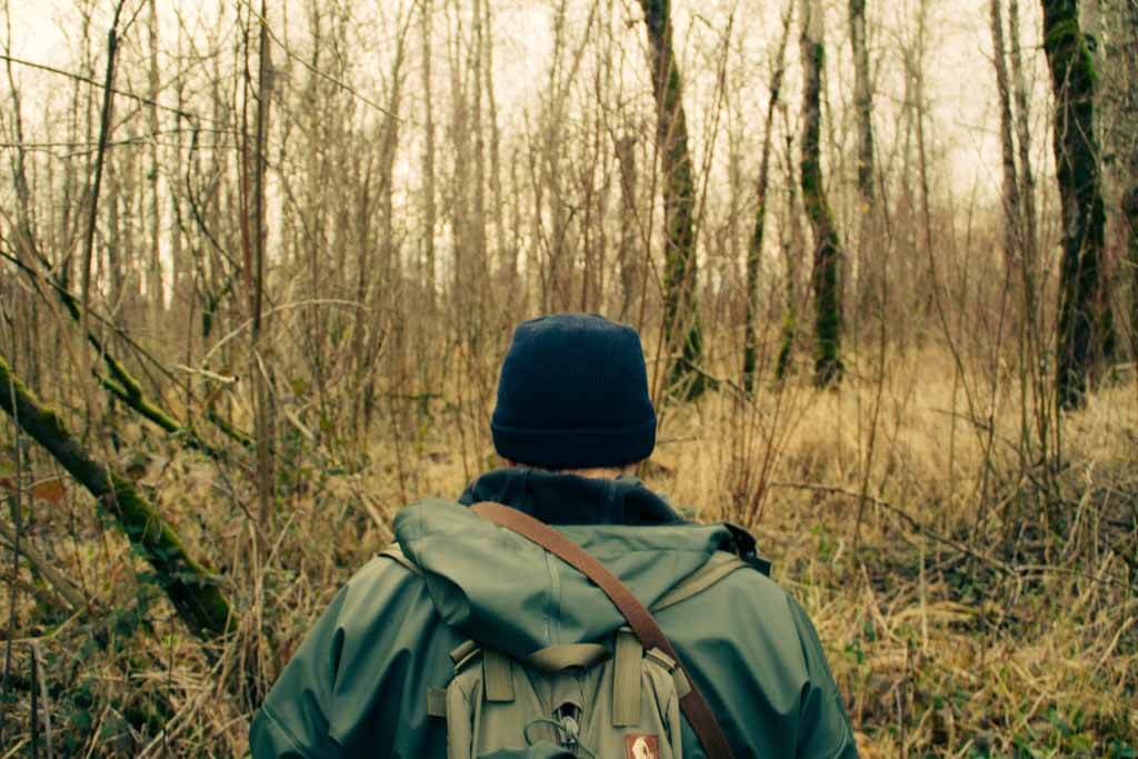 man walking through wooded tract